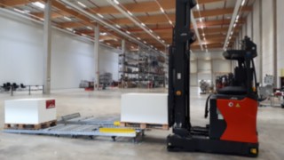 The automated R-MATIC reach truck from Linde Material Handling can put down and pick up loads more precisely. Automated R-MATIC reach truck from Linde Material Handling putting down goods.
