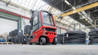 The comprehensive decoupling concept with the elastomer ring bearing for shock absorption on the front axle reduces the physical strain on the driver. Linde Material Handling E30 electric forklift truck transports a roll of wire