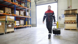 A Linde Material Handling technician walking through a warehouse