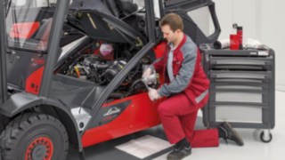 Linde service technician is changing the oil filter Linde service technician is changing the oil filter
