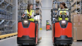 Two employees drive N20 series order pickers from Linde Material Handling in the warehouse.