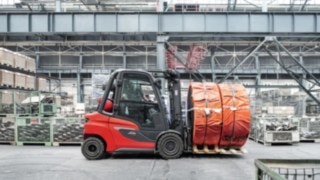 Several assistance systems increase the safety for people, truck, and surroundings. H30 IC truck transporting goods in the warehouse