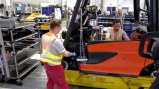 Two employees in production keep a safe distance thanks to the Distance Vest from Linde