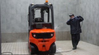 A Linde employee cleans the used forklift before the incoming check.