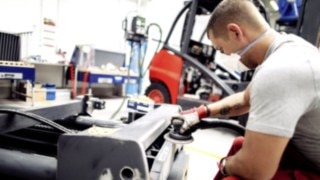 Individual components of the used forklift are overhauled and cleaned by an employee.