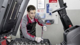 A service technician checks the drive battery of a Linde used forklift