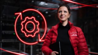 Linde Material Handling employee in a warehouse with a red LED symbol of a gear wheel in the background.