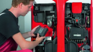 Technician retrofits a forklift truck with Linde components Technician retrofits a forklift truck with Linde components