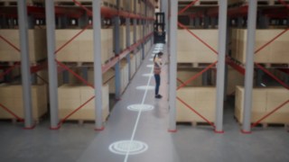 Animation of an employee in a protective vest in a narrow-aisle warehouse and the safety zones for person recognition