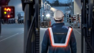 Man with Linde's pedestrian warning belt and safety helmet from behind