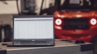 Forklift trucks and warehouse handling equipment often come equipped with modern telemetry systems as standard. Laptop in front of a forklift truck from Linde Material Handling