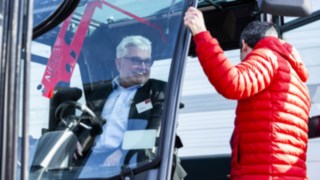 Man sitting in the driver´s cabin of a new Linde MH forklift truck at the Linde Automation Summit