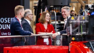 Ulrike Just, Member of the Executive Board at Linde MH, talking to three visitors at LogiMAT.