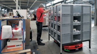 An ABS Safety employee picks parts from a rack that the Linde MH C-MATIC has brought to him.
