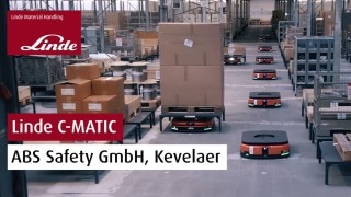 The Linde Material Handling logo and the text “Linde C-MATIC ABS Safety GmbH, Kevelaer” appear in a photo showing several C-MATIC vehicles in the ABS Safety warehouse.