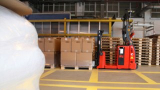 The automated Linde Material Handling L-MATIC AC pallet stacker transports pallets at BASF Italia.