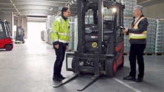 Two CTL employees stand next to the E30 electric forklift truck from Linde Material Handling.