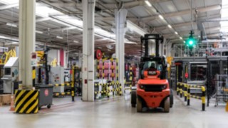 A forklift truck by Linde Material Handling waits at a Linde Safety Guard traffic light in the plant operated by Coca-Cola European Partners France.