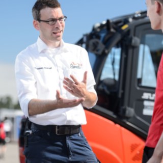 Johannes Kratzel, Head of Event Support, in discussion with Formula Student volunteers in front of a Linde forklift truck Johannes Kratzel, Head of Event Support, in discussion with Formula Student volunteers