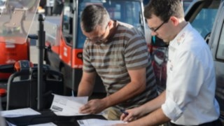A Linde employee goes through the handover report for rental trucks with Johannes Kratzel