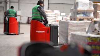Two T20 SP lithium-ion pallet trucks from Linde Material Handling receive incoming goods.
