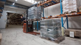 An employee of Reinheim-based Grass GmbH working in the warehouse with a Linde Material Handling pallet stacker