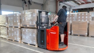 A warehouse operator from K2 Systems operates a Linde D12 HP SP double-deck pallet stacker