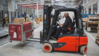 A Linde electric forklift truck transports a mesh box