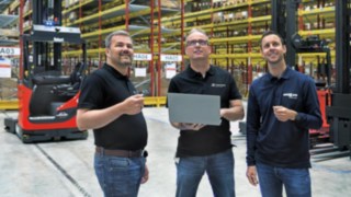 Oliver Sitzmann and Marcus Wieland, both from Simon Hegele, and Thomas Eußner, from Ernst Müller Fördertechnik, stand next to each other in the warehouse.