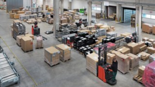 Simon Hegele’s logistics warehouse with employees sorting and transporting pallets of goods.