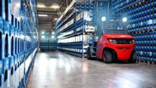 A Linde electric forklift in front of blue beverage crates.