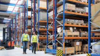 Yanmar Compact Equipment Europe employees walk through the new logistics center, which was planned by Linde Material Handling