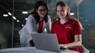 Executive explaining something to a colleague over a laptop computer.