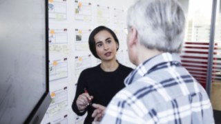 Young woman explains Linde employee something on a chart Young woman explains Linde employee something on a chart
