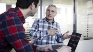 Linde Employee with young man with laptop in a meeting room