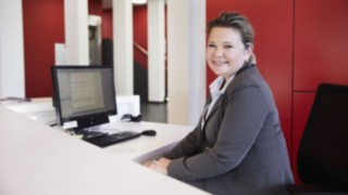 Linde employee at reception with computer Linde employee at reception with computer