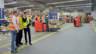 Linde Safety Scan is used in the field. Three people analyze the occurrences in a factory building.