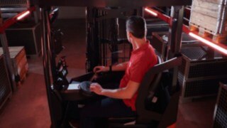 Driver seated in the ergonomic workspace of the Linde MH reach truck Ri16.