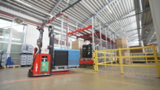 A Linde L-MATIC HD feeds goods to a conveyor belt.