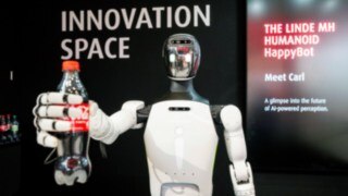 Carl, the humanoid robot, hands over a Coke