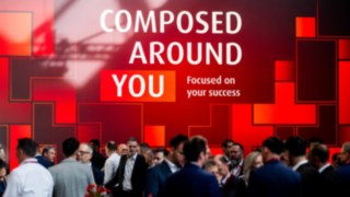 Exhibition wall featuring the slogan “Composed around you”