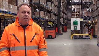 Man in high-visibility clothing in a warehouse.